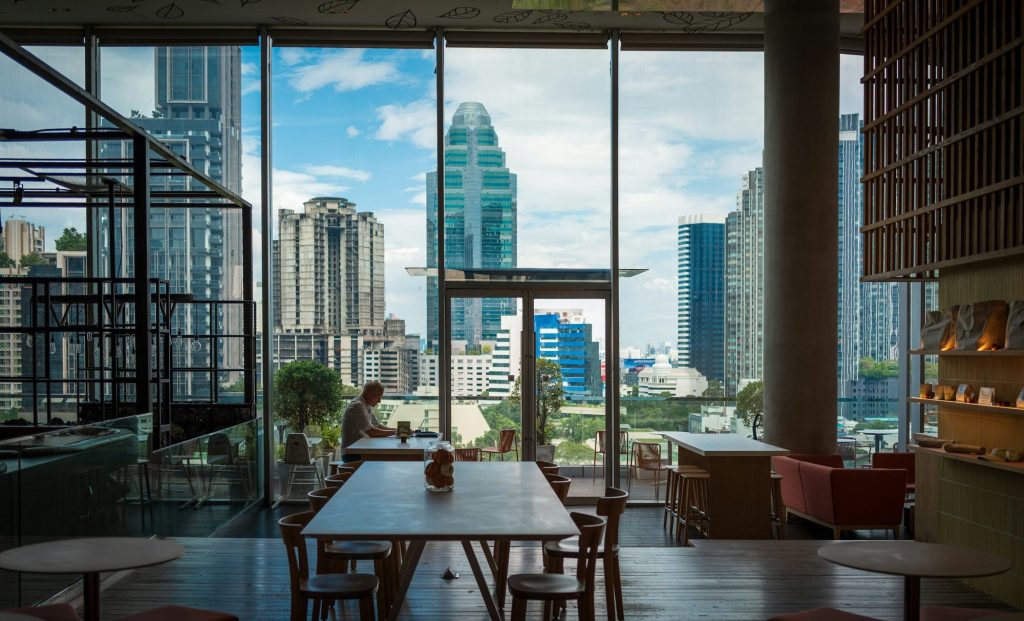 Comedor de un restaurante con grandes ventanales y vistas a los rascacielos