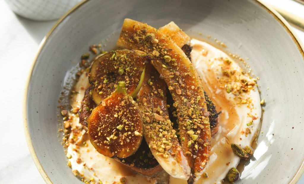 Postre de higos con crema sobre un plato blanco