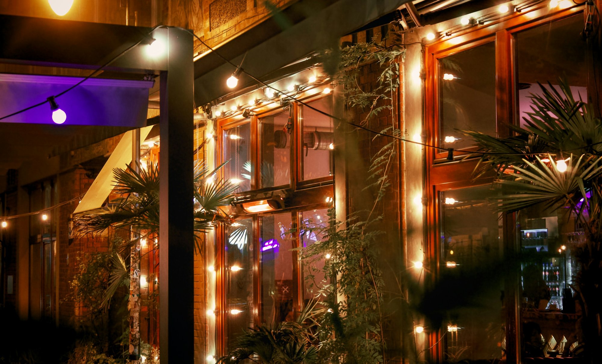 Fachada iluminada de un restaurante al anochecer